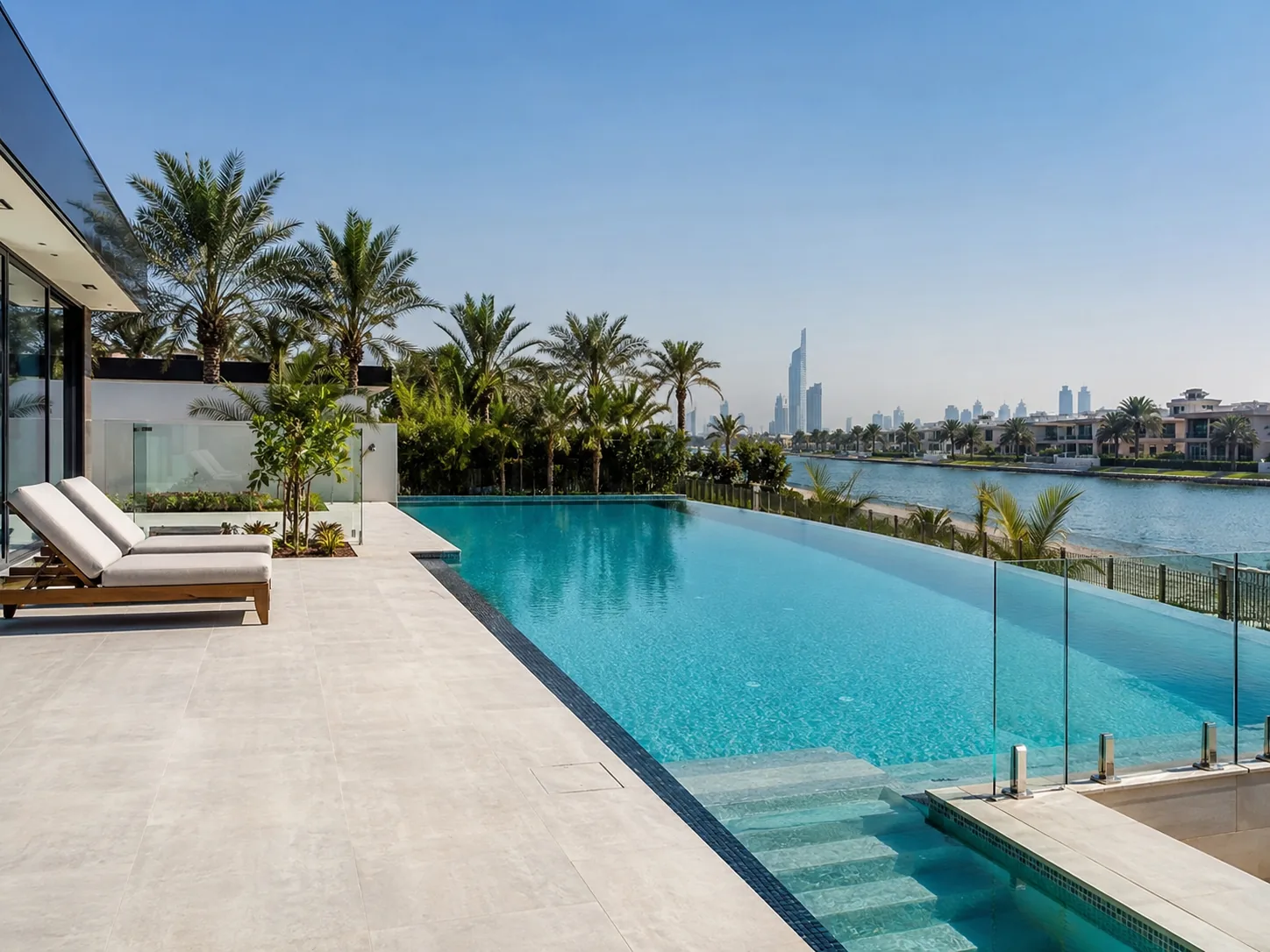Infinity swimming pool beside a modern waterfront villa